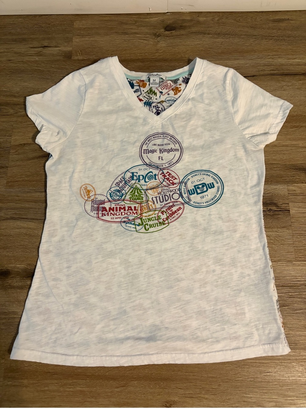 Disney Parks White V-Neck Tee with Multicolor Stamp Graphic